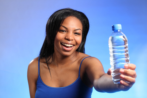 Beautiful girl laughing and holding bottled water - Фото, изображение