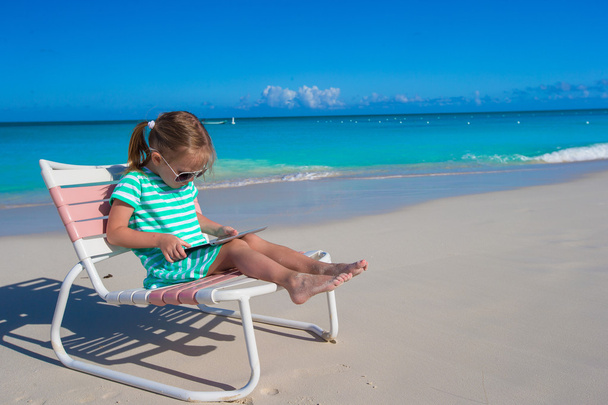 Маленька дівчинка з ноутбуком на пляжі під час літніх канікул
 - Фото, зображення