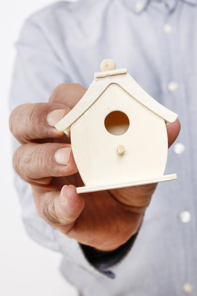 Man holding tiny wooden house - Фото, зображення