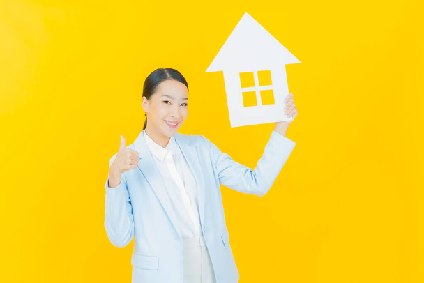 Muotokuva kaunis nuori aasialainen nainen talon tai kodin paperi merkki väri tausta - Valokuva, kuva