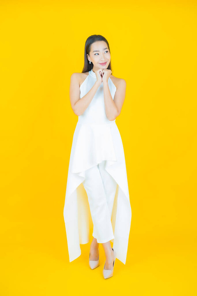 Portrait beautiful young asian woman smile with action on color background - 写真・画像