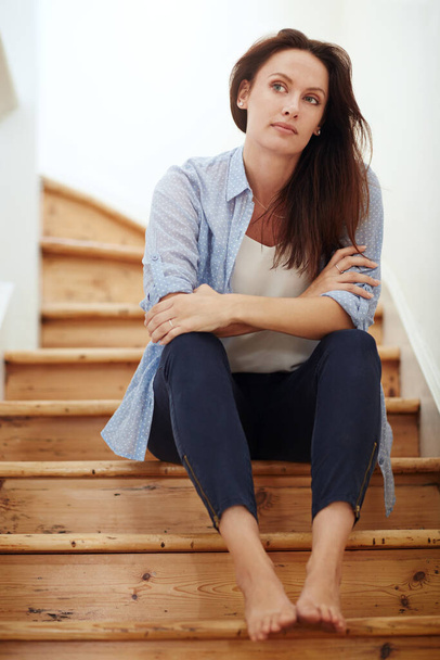 Im missing something in my life...a young woman sitting on the staircase at home - Foto, afbeelding