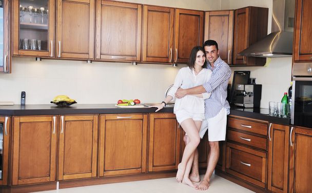 Happy young couple have fun in modern kitchen - Foto, imagen