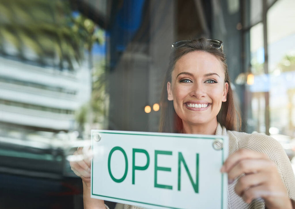 The start of another successful day. Portrait of a young entrepreneur holding an open sign in her business - Fotoğraf, Görsel