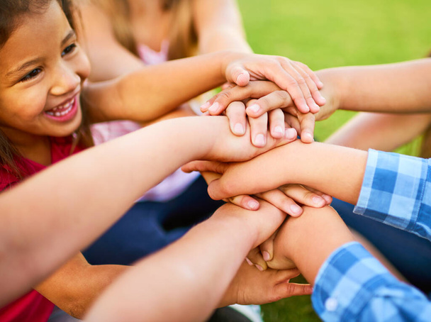 Дай миру повод улыбаться. группа детей, укладывающих руки друг на друга - Фото, изображение