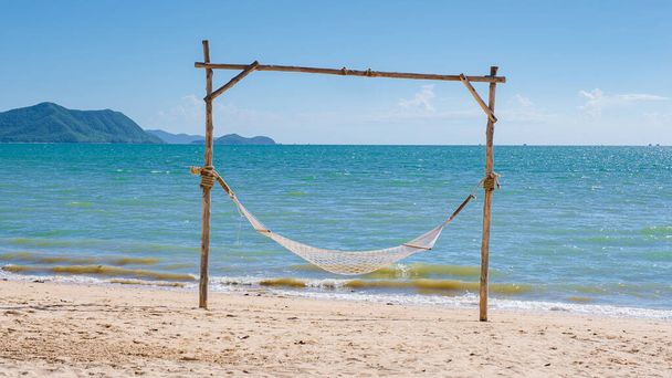 Hammock on the beach of Ban Amphur Beach Pattaya Thailand, a beach with beautiful palm trees and a blue ocean in Pattaya Thailand - Foto, afbeelding