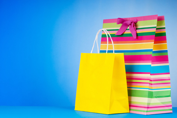 Colourful paper shopping bags against gradient background - Foto, Imagem