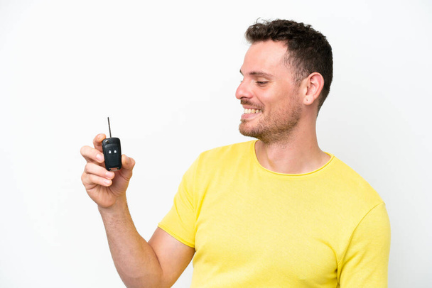 Young man holding car keys isolated on white background with happy expression - Foto, immagini