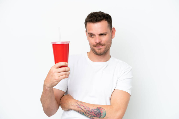 Young caucasian soda holding soda isolated on white background with sad expression - Фото, изображение