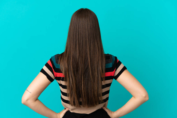 Подросток бразильская девушка на изолированном синем фоне в задней позиции - Фото, изображение