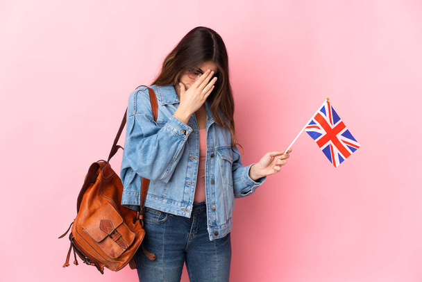 Young woman holding an United Kingdom flag isolated on pink background with tired and sick expression - Zdjęcie, obraz