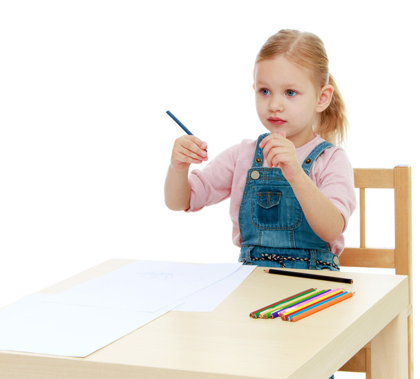 Mała dziewczynka rysuje ołówki siedzi przy stole. - Zdjęcie, obraz