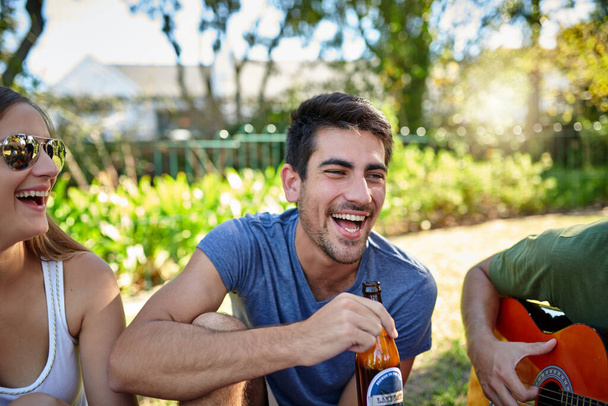 Άσε τις καλές στιγμές να κυλήσουν. μια νεαρή ομάδα φίλων απολαμβάνοντας μερικά ποτά έξω στον καλοκαιρινό ήλιο - Φωτογραφία, εικόνα
