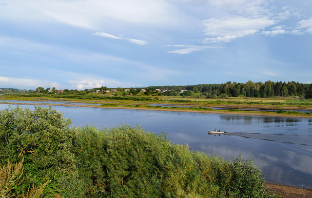 River landscape with a motorboat - 写真・画像