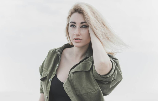 Modern blonde woman mix race in jeans jacket, fashionable details on a model, concept of trend in wardrobe - Zdjęcie, obraz