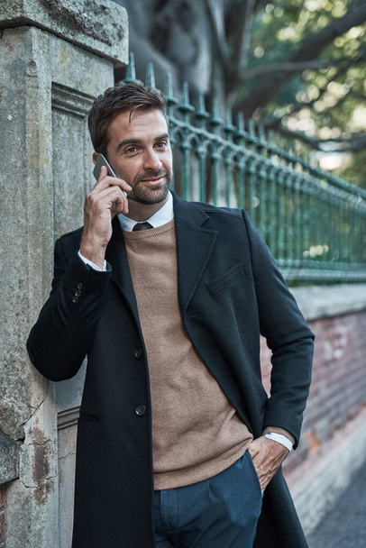 Ill be back in the office shortly. a handsome businessman using his cellphone while about town - Foto, imagen