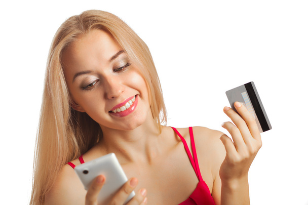 young woman doing online shopping while holding a credit card is - Foto, immagini