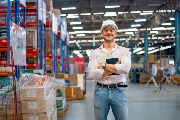 Smart professional warehouse manager stand with arm-crossed action and holding tablet also smile to camera in workplace area. - Fotografie, Obrázek