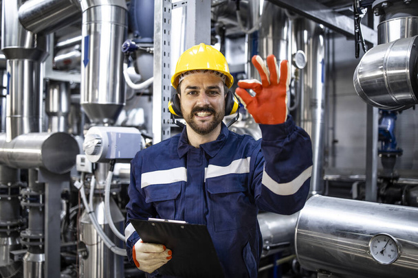 Successful power production and refinery worker holding okay sign. - Fotó, kép