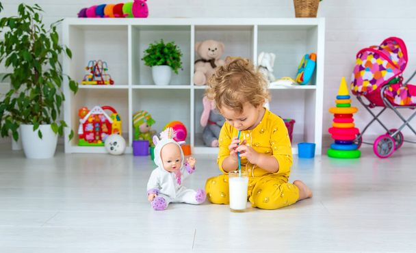 Child drink milk in the room. Selective focus. Kid. - Fotó, kép