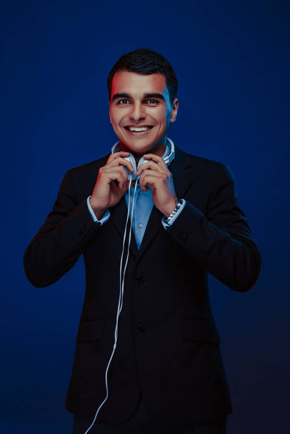 Portrait of smiling man with headphones on dark background. Studio shoot.  - Φωτογραφία, εικόνα