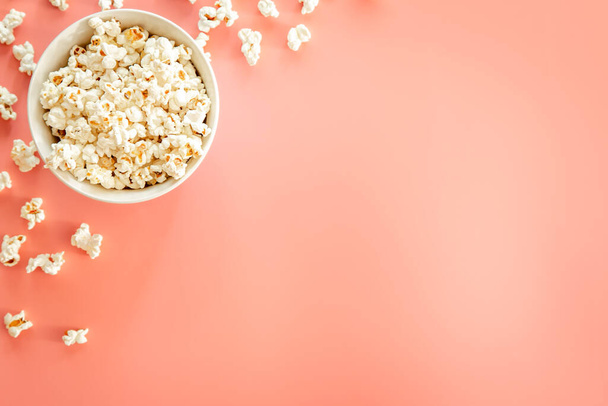 Popcorn on pink background, flat lay, concept of watching movies and series. - Fotó, kép