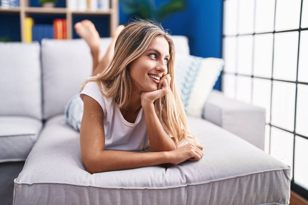 Young blonde woman smiling confident lying on sofa at home - Foto, Imagem