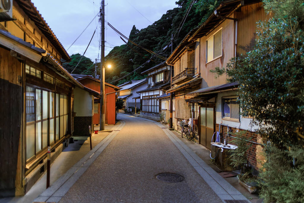 Buildings line deserted road through quiet Japanese village at dusk. High quality photo - Foto, immagini
