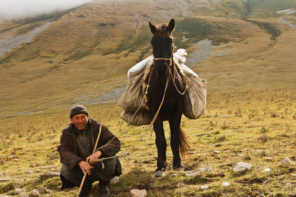 Pastore uomo che tiene un cavallo per la briglia
 - Foto, immagini