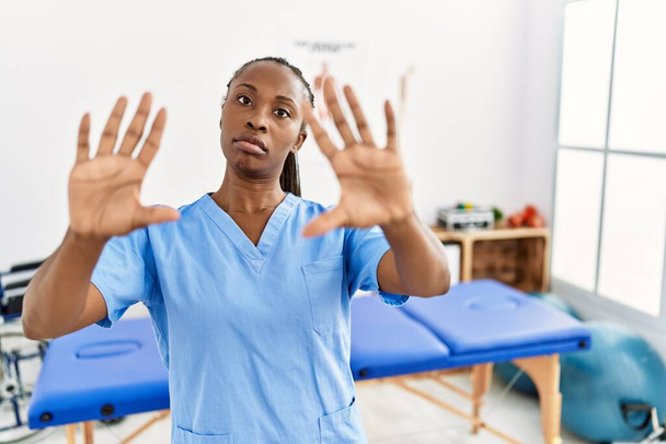 Black woman with braids working at pain recovery clinic doing frame using hands palms and fingers, camera perspective  - Foto, immagini