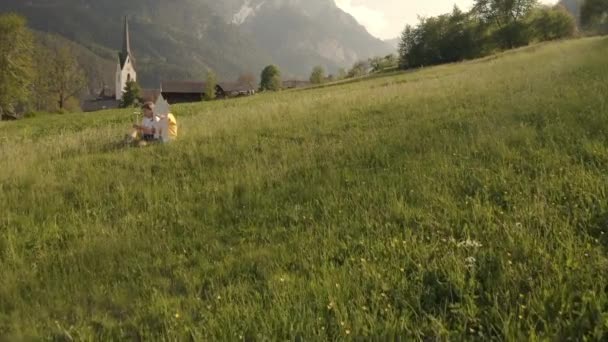 El hermano y la hermana están sentados en el campo contemplando el paisaje. Imágenes de alta calidad 4k - Imágenes, Vídeo