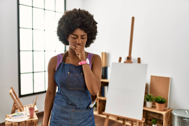 Fiatal afro-amerikai nő afro hajjal a művészeti stúdióban rossz közérzet és köhögés tüneteként hideg vagy hörghurut. az egészségügyi ellátás fogalma.  - Fotó, kép