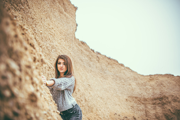 Kaunis nuori nainen ulkona louhoksessa hiekan kanssa
 - Valokuva, kuva