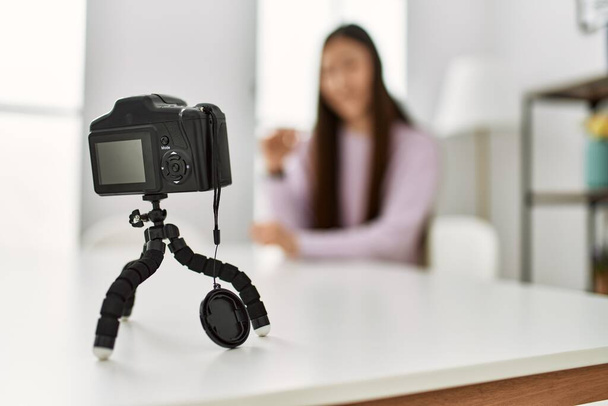 Nuori kiinalainen tyttö, jolla on videopuhelu kameran avulla istuu pöydällä kotona. - Valokuva, kuva