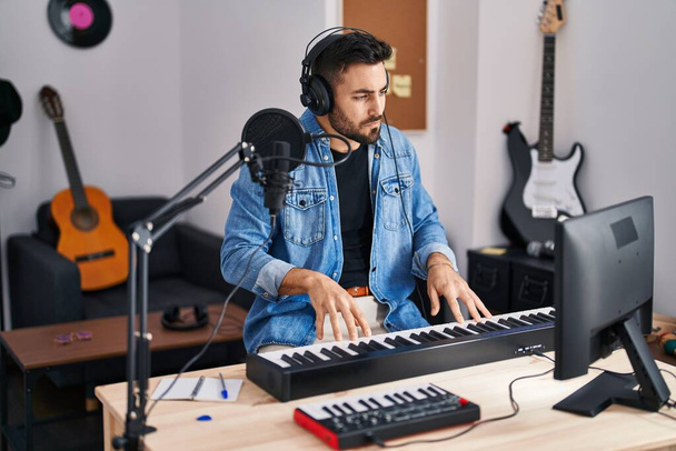Молодой латиноамериканец композитор сочиняет песни в музыкальной студии - Фото, изображение