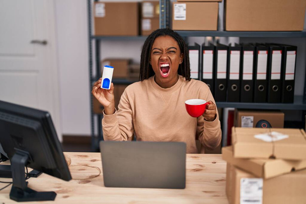 小さなビジネスで働く若いアフリカ系アメリカ人は、怒り狂った怒りと怒りで叫び、怒りで叫んで、怒りでコーヒーを飲んでいます。怒りと攻撃的な考え方.  - 写真・画像
