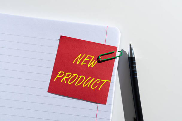 Conceptual caption New Product, Business concept goods and services that differ in their characteristics Sticky Note With Important Idea Clipped On Opened Notebook On Desk With Pen - Fotó, kép