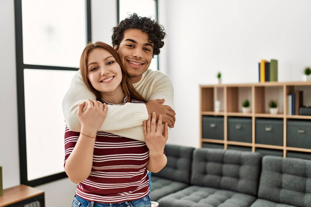 Young couple smiling happy and hugging standing at home. - Photo, image