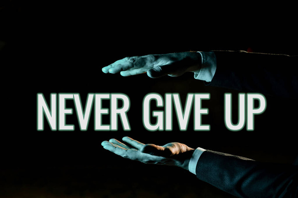 Text sign showing Never Give Up, Business overview Keep trying until you succeed follow your dreams goals Businessman Presenting Important Informations Between Hands. - Foto, Bild