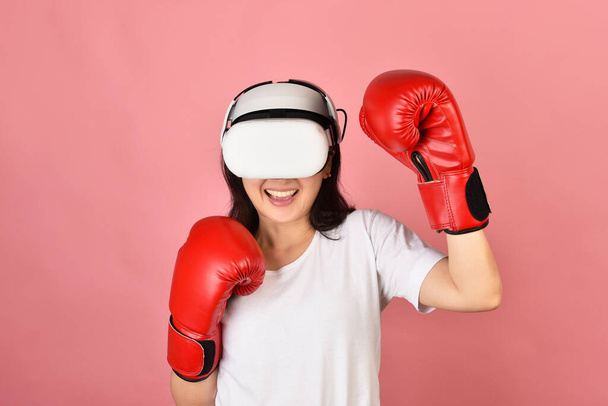 Asian woman using vr glasses, Working out with boxing video games application from virtual reality headset, Young woman enjoy new fitness experience by vr technology, Studio shot. - Φωτογραφία, εικόνα