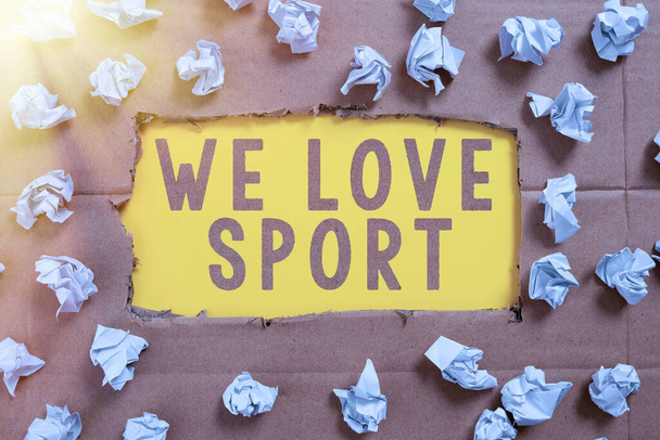 Sign displaying We Love Sport, Business idea To like a lot practicing sports athletic activities work out Important Ideas Written Under Ripped Cardboard With Paper Wraps Around. - Foto, imagen