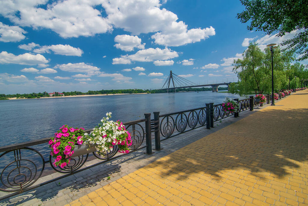 Embankment of Dnieper river in Natalka public park in Obolon district, Kyiv, Ukraine. North Cable Bridge on background - Fotó, kép