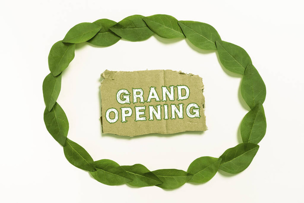 Sign displaying Grand Opening, Business idea Ribbon Cutting New Business First Official Day Launching Blank Color Paper Between Leaves Wreath For Wedding Invitation. - Photo, image
