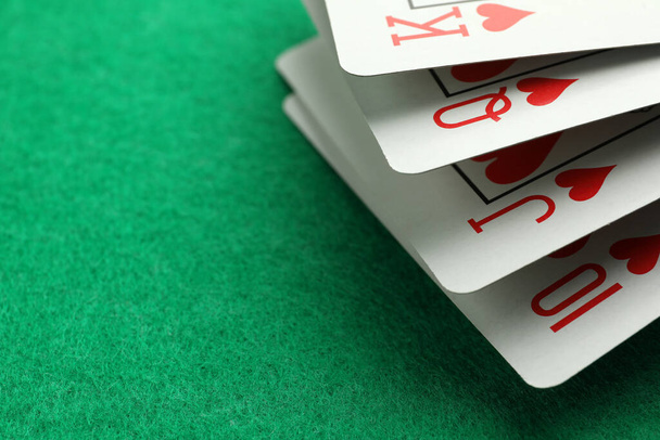 Hand of playing cards on green table, closeup. Space for text - Фото, изображение