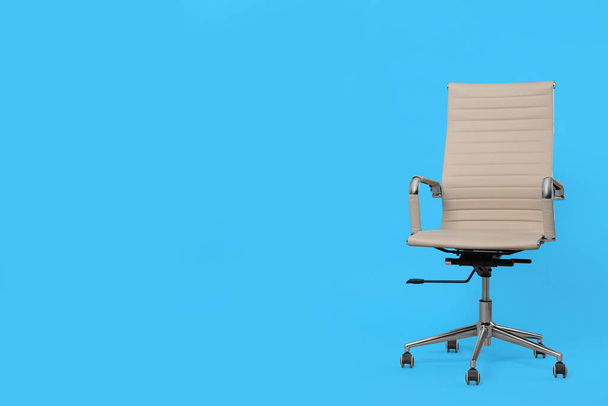 Comfortable office chair on light blue background, space for text - Zdjęcie, obraz