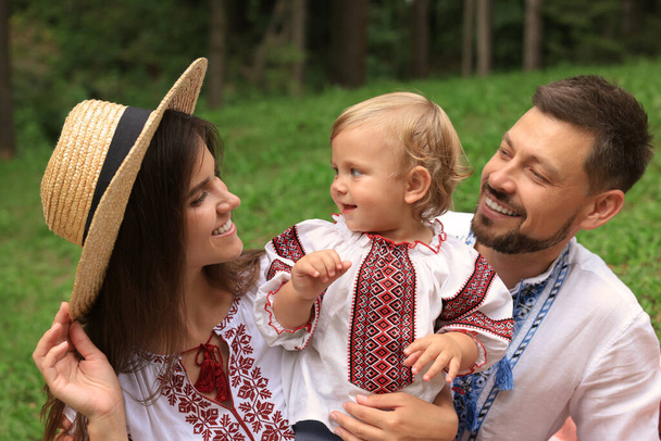 Happy family in Ukrainian national clothes outdoors - Fotó, kép