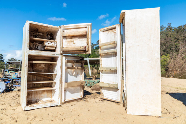 Photograph of severely flood damaged refrigerators on a white sandy area of land near the Hawkesbury river in New South Wales in Australia - Fotografie, Obrázek