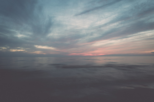 hosszú expozíciós drámai kék naplemente kimossák a hullámok - retro - Fotó, kép