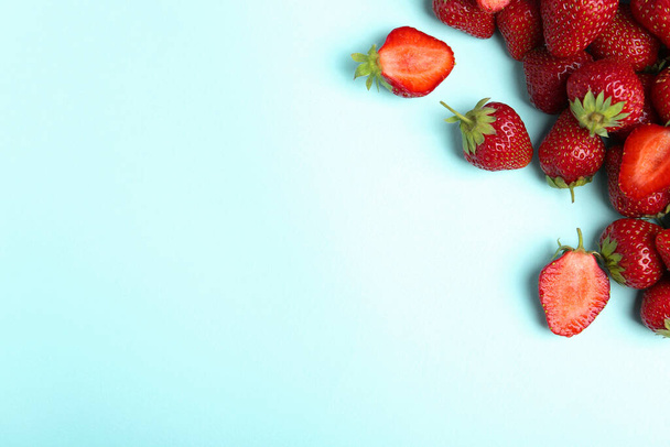 Tasty ripe strawberries on light blue background, flat lay. Space for text - Zdjęcie, obraz