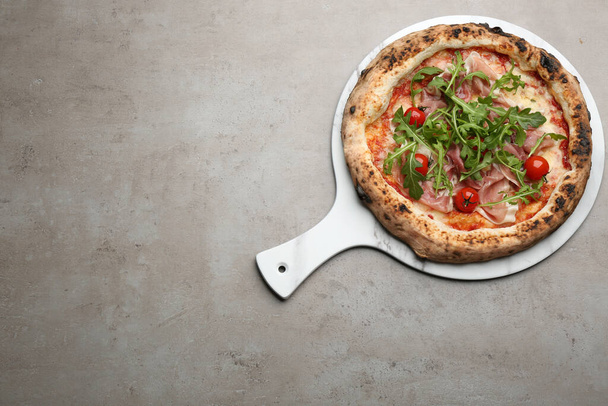 Tasty pizza with meat and arugula on grey table, top view. Space for text - Fotografie, Obrázek